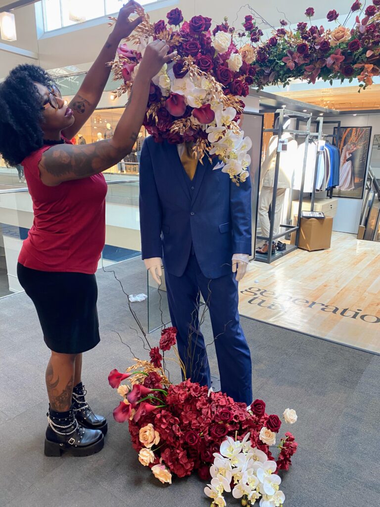 florist making fall floral installation at jersey gardens mall